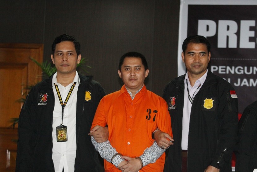 Polisi mengawal tersangka kasus penipuan PT First Travel Andika Surachman (tengah) saat gelar perkara kasus penipuan PT First Travel di Bareskrim Polri, Jakarta, Selasa (22/8). 