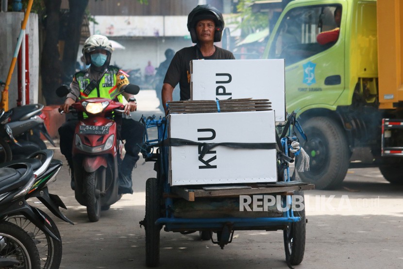 Polisi mengawal tukang becak yang mengangkut logistik hasil Pemilu 2019 di Jalan Tambak Sari, Surabaya, Jawa Timur, Kamis (18/4/2019).