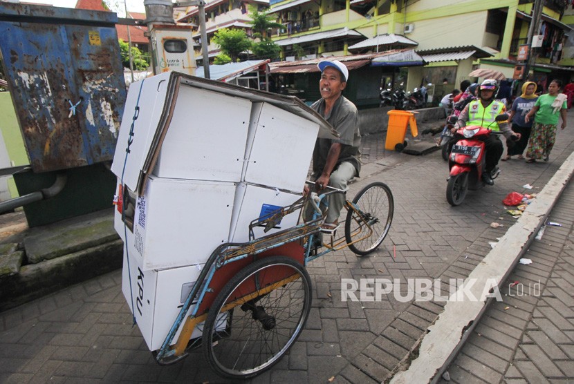 Polisi mengawal tukang becak yang mengangkut logistik hasil Pemilu 2019 di Rusun Sumbo, Surabaya, Jawa Timur, Kamis (18/4/2019).