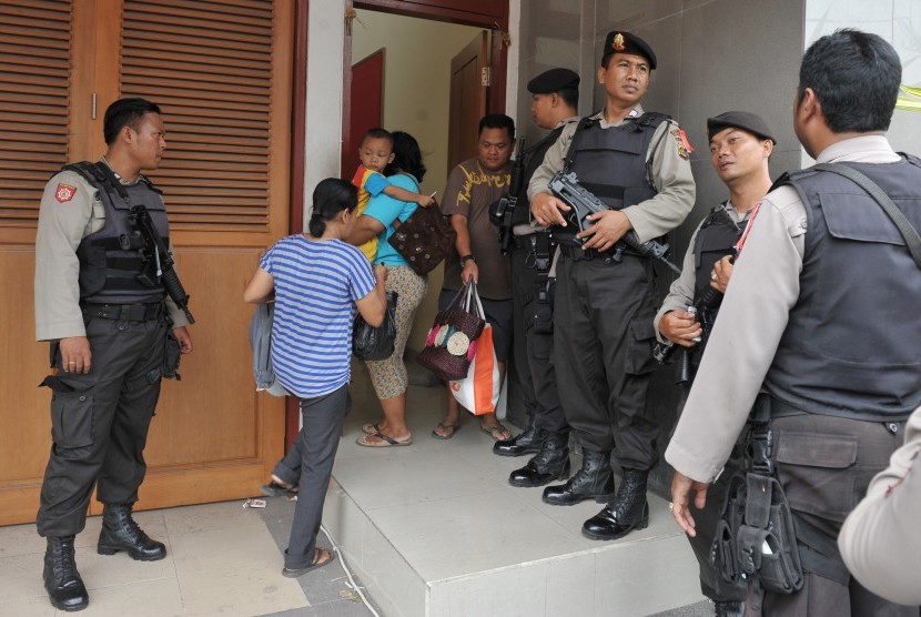  Polisi mengawasi lalu lalang pembesuk di pintu Lembaga Pemasyarakatan (Lapas) Kerobokan pasca bentrokan, Denpasar, Jumat (18/12). 