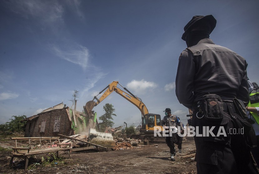 Polisi mengawasi proses pembongkaran rumah pada pengosongan lahan untuk pembangunan New Yogyakarta International Airport (NYIA) di Kulonprogo, DI Yogyakarta, Senin (4/11). 