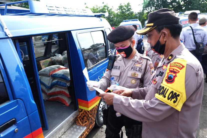 Polisi mengecek data penerima bantuan sembako warga miskin dalam penanganan tanggap darurat Kejadian Luar Biasa (KLB) wabah COVID-19 di Pedaringan, Solo, Jawa Tengah, Minggu (5/4/2020). Bantuan sembako tersebut diserahkan bagi 40 ribu keluaga rentan miskin di Solo yang sebagian diantaranya terdata dari Sistem Informasi Kesejahteraan Elektronik.