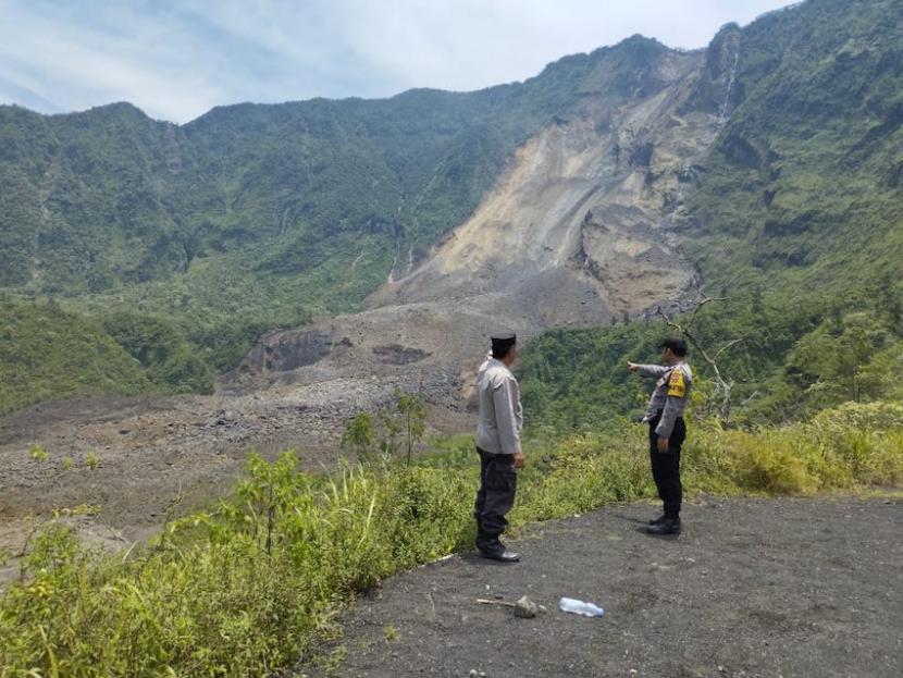 Polisi mengecek longsor di dinding kawah Gunung Galunggung, Desa Linggajati, Kecamatan Sukaratu, Kabupaten Tasikmalaya, Jawa Barat, Ahad (12/3/2023).  Dinding kawah Gunung Galunggung, Tasikmalaya longsor karena kondisi tanah yang labil.