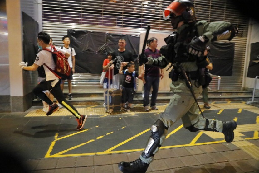 Polisi mengejar seorang pengunjuk rasa Hong Kong, Ahad (13/10). Pengunjuk rasa mengubah strategi mereka untuk menghindari penangkapan.