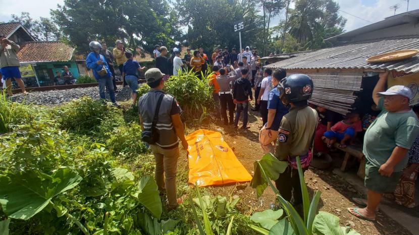 Polisi mengevakuasi korban meninggal dunia akibat tertabrak kereta api di Desa Manonjaya, Kecamatan Manonjaya, Kabupaten Tasikmalaya, Rabu (8/7/2022). 