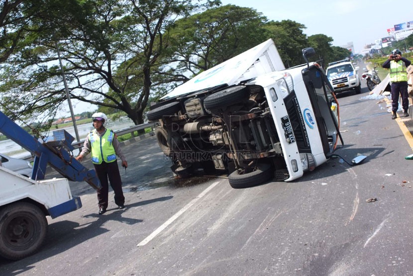 Polisi mengevakuasi mobil box yang Terguling di Jl Tol Prof Sediyatmo,  Jakarta, Jumat (2/5).  (Republika/Yogi Ardhi)