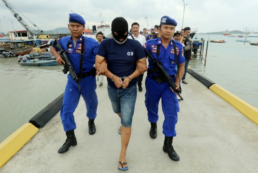 Polisi menggiring kurir narkoba berinisial, GN yang ditangkap beserta barang bukti tiga kilogram sabu serta 15 butir ekstasi di Mapolair Polda Kepri, Batam, Provinsi Kepulauan Riau, Senin (7/3). 