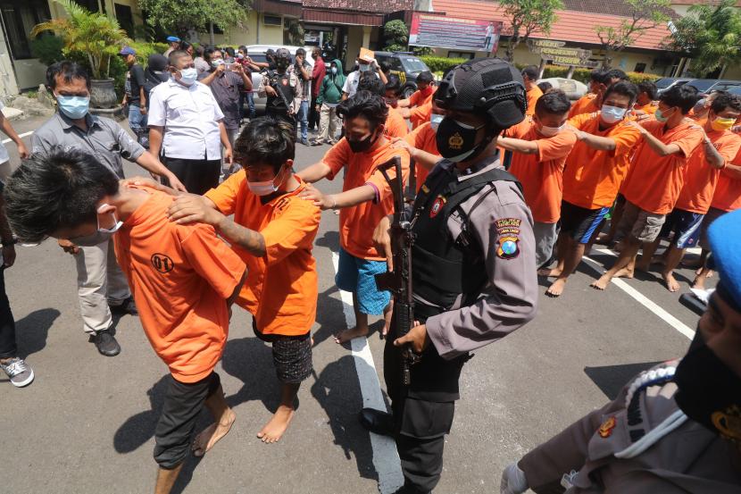 Polisi menggiring sejumlah tersangka saat ungkap kasus peredaran narkoba bulan Februari-Maret 2021 di Polresta Kediri, Jawa Timur, Selasa (16/3/2021). Polresta Kediri berhasil mengamankan 41 tersangka dari 30 kasus narkoba dengan barang bukti terbanyak berupa 142.592 butir pil double L atau Triheksifenidil Hcl.