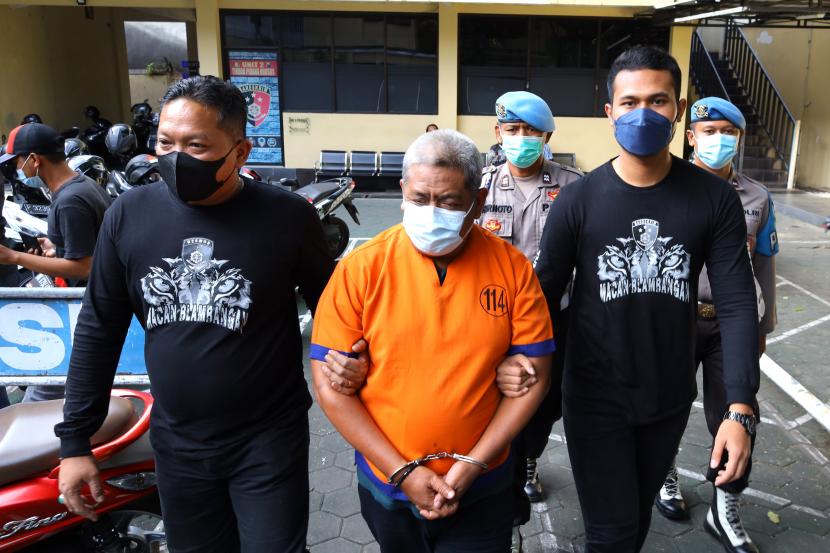 Polisi menggiring tersangka FA (52 tahun) kasus pencabulan di Mapolresta Banyuwangi, Jawa Timur, Kamis (7/7/2022). Polisi berhasil mengungkap kasus pencabulan yang dilakukan oleh pimpinan Pondok Pesantren kepada satu santri putra dan lima santri putri.