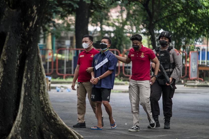 Polisi menggiring tersangka NFM (kedua kiri) untuk memperagakan kasus dugaan kekerasan hingga mengakibatkan tewasnya mahasiswa dalam Diklatsar Menwa UNS saat reka ulang di kawasan Stadion Manahan, Solo, Jawa Tengah, (ilustrasi).
