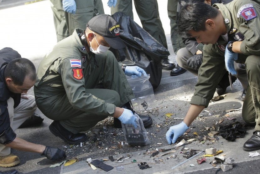 Polisi Thailand memeriksa puing-puing bekas ledakan bom di Bangkok , Thailand , Selasa, (18/8).