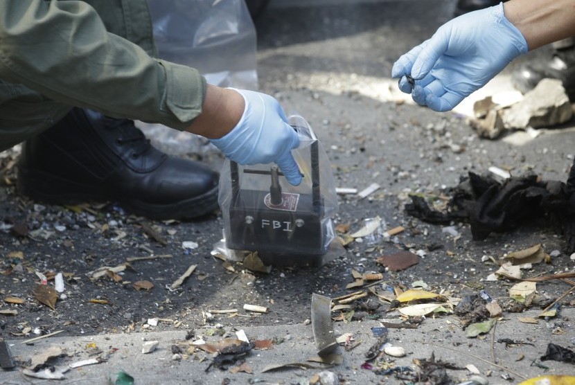 Polisi Thailand memeriksa puing-puing bekas ledakan bom di Bangkok , Thailand , Selasa, (18/8).