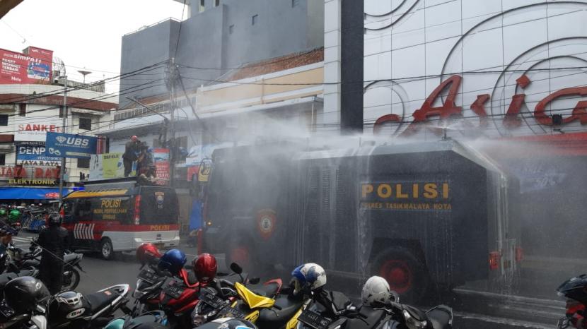  Selama Sebulan Kota Tasikmalaya akan Karantina Wilayah. Foto: Polisi menggunakan kendaraan water cannon untuk menyemprotkan disinfektan di kawasan kota Tasikmalaya, Selasa (24/3)