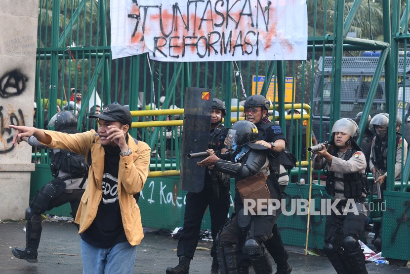 Polisi menghalau massa saat kericuhan dalam unjuk rasa di depan kompleks Parlemen di Jakarta, Selasa (24/9/2019).