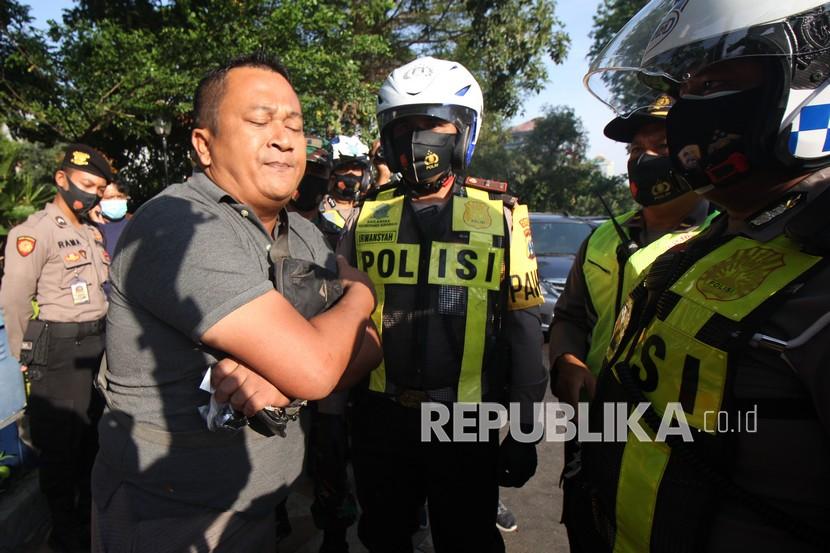 Polisi menghentikan pengendara yang tidak menggunakan masker saat Operasi Yustisi 