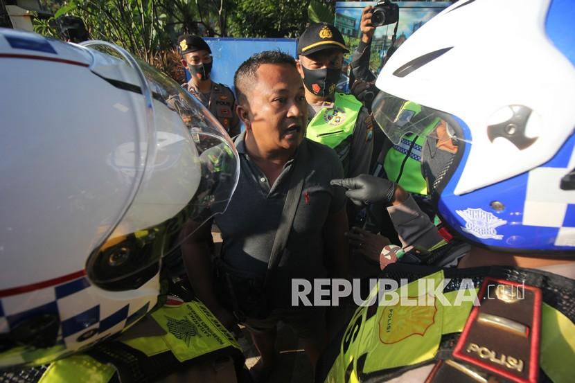 Polisi menghentikan pengendara yang tidak menggunakan masker saat Operasi Yustisi Penegakan Disiplin Protokol Kesehatan di Surabaya, Jawa Timur. (Ilustrasi)