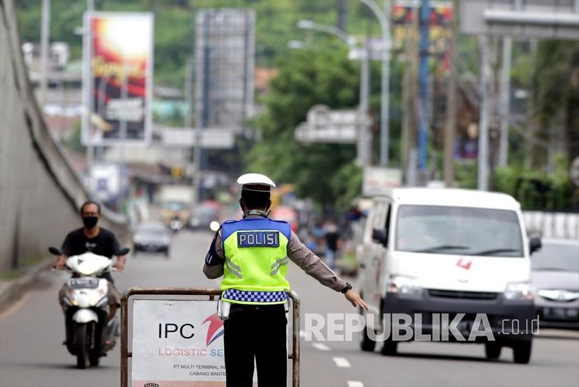 Polisi menghentikan sejumlah kendaraan yang lewat di pintu masuk Pelabuhan Merak di Cilegon, Banten, Selasa (19/5/2020). Menurut petugas sejak pemerintah melarang mudik Idul Fitri sebagai tindakan untuk mencegah penyebaran virus korona, polisi berhasil membuat 942 kendaraan pribadi, yang akan menyebrang ke Sumatera, putar balik