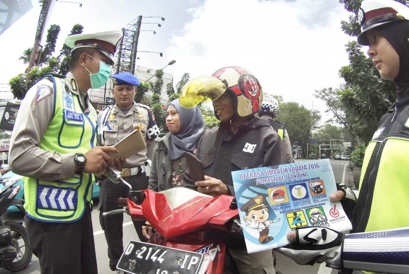 Polisi mengingatkan pengendara motor yang boncengannya tidak menggunakan helm saat pelaksanaan 'Operasi Simpatik Lodaya' 