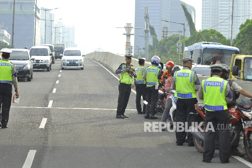 Polisi menindak kendaraan roda dua yang melanggar kareng melintas Jalan Layang Non Tol (JLNT) Kampung Melayu-Tanah Abang, Jakarta, Kamis (27/7). 