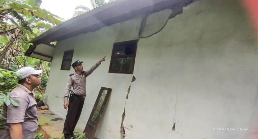 Polisi meninjau keretakan rumah yang makin parah akibat gempa. BPBD Garut sebut sebanyak 511 rumah rusak akibat gempa diusulkan dapat bantuan.