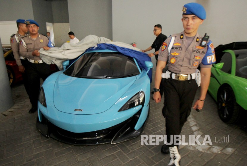 Polisi menjaga sejumlah mobil mewah yang diamankan di Polda Jawa Timur, Surabaya, Jawa Timur, Senin (16/12/2019).