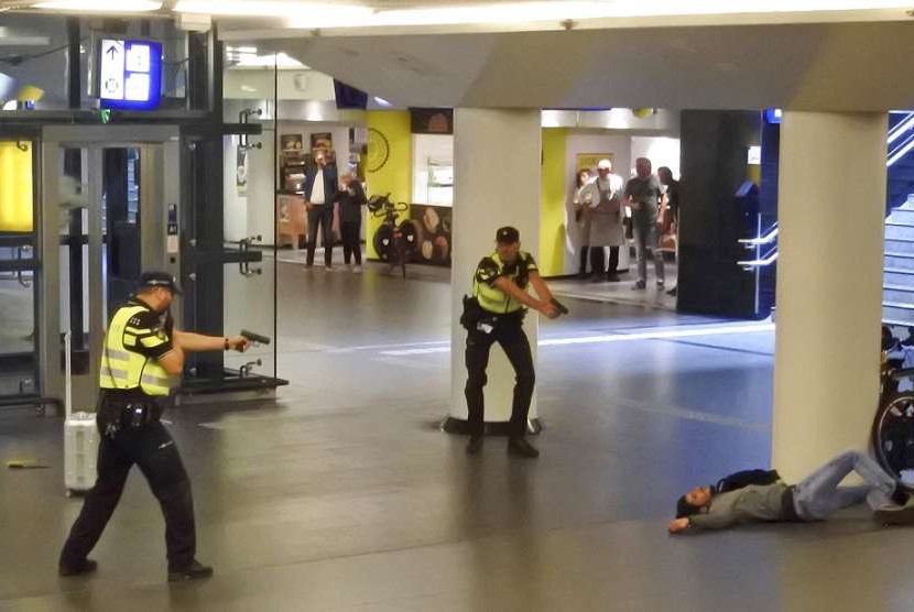 Polisi menodongkan senjata pada tersangka penusuk dua turis AS di stasiun sentral Amsterdam, Jumat (31/8).