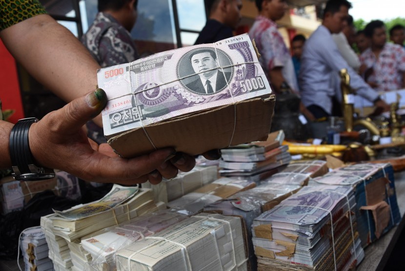 Polisi menunjukkan barang bukti berupa mata uang asing dari tersangka penipu Dimas Kanjeng Taat Pribadi ketika ungkap kasus di Mapolda Jawa Timur, Jumat (7/10).
