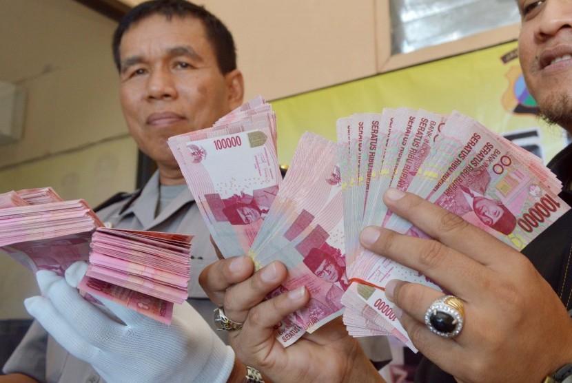 Polisi menunjukkan barang bukti sejumlah uang palsu pecahan Rp 100 ribu di Mapolres Ngawi, Jatim, Rabu (18/3). 