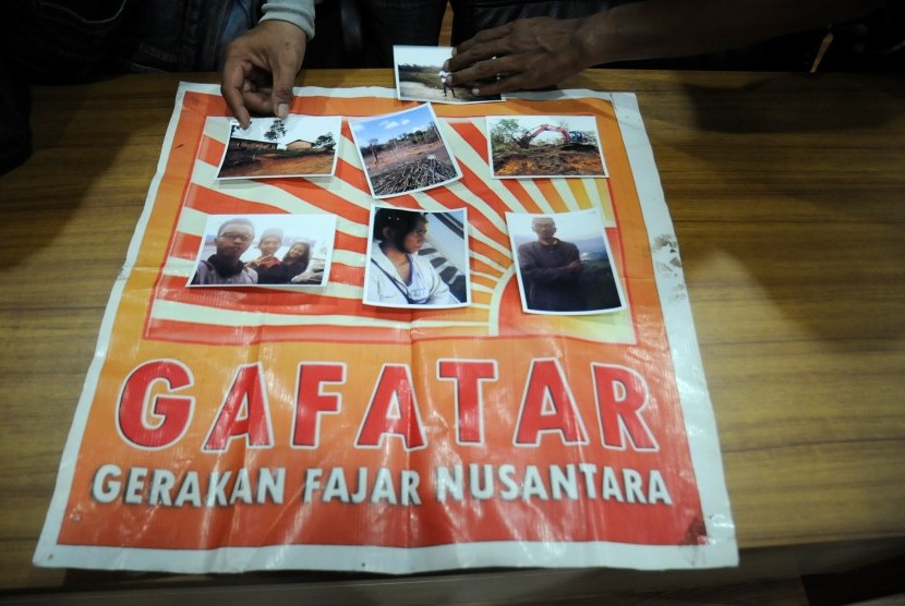Polisi menunjukkan foto satu keluarga yang hilang berikut atribut bendera Gerakan Fajar Nusantara (Gafatar) di Mapolresta Depok, Jawa Barat, Selasa (19/1).