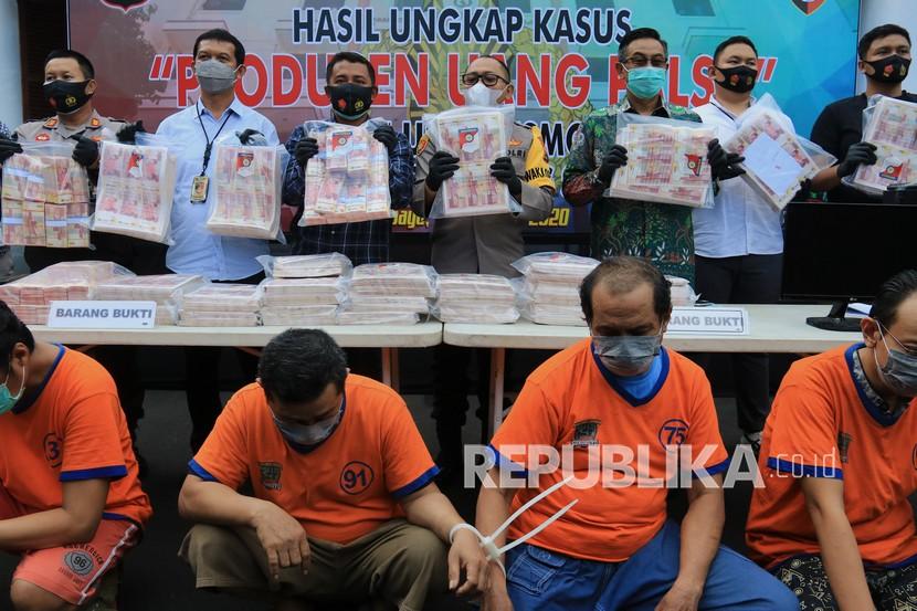 Aparat dan petugas BI Jatim menunjukkan tersangka dan barang bukti saat rilis kasus pembuatan dan peredaran uang palsu di Markas Polrestabes Surabaya, Jawa Timur, Kamis (5/11).