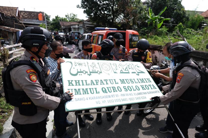 Polisi menurunkan papan bertulis Khilafatul Muslimin dari rumah warga sekaligus kantor cabang kelompok tersebut di Solo, Jawa Tengah, Kamis (9/6/2022). Kegiatan tersebut sebagai upaya menghentikan penyebaran paham kelompok Khilafatul Muslimin yang membahayakan ideologi Pancasila.