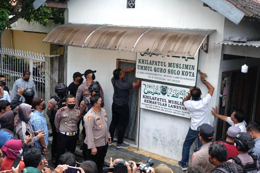 Polisi menurunkan papan bertulis Khilafatul Muslimin dari rumah warga sekaligus kantor cabang kelompok tersebut di Solo, Jawa Tengah, Kamis (9/6/2022). Kegiatan tersebut sebagai upaya menghentikan penyebaran paham kelompok Khilafatul Muslimin yang membahayakan Ideologi Pancasila. 