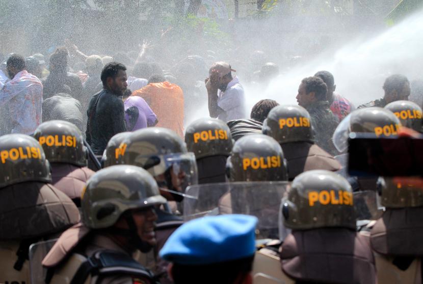 Polisi menyemprotkan air untuk membubarkan para pengunjuk rasa yang tergabung dari berbagai elemen mahasiswa di Jalan Buper, Waena, Kota Jayapura, Papua, Selasa (10/5/2022). Aksi tersebut sebagai bentuk penolakan atas pemekaran Daerah Otonomi Baru (DOB) di Papua.