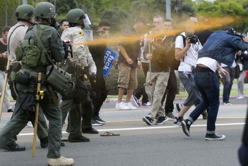 Polisi menyemprotkan cairan merica ke arah demonstran yang berunjuk rasa saat kampanye calon presiden AS Donald Trump di San Diego, Jumat, 27 Mei 2016.