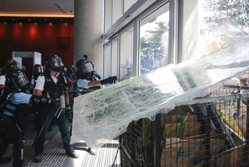 Polisi menyemprotkan lada ke demonstran yang merusak dinding kaca Dewan Legislatif Hong Kong di Hong Kong, Senin (1/7).