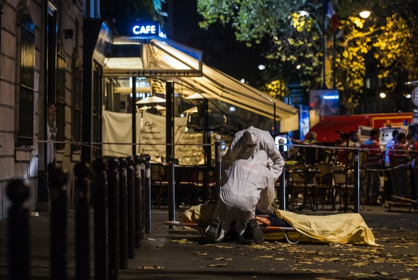 Polisi sedang memeriksa tubuh korban tewas serangan penembakan di luar gedung konser Bataclan di Paris, Prancis, Jumat (13/11).