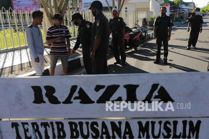 Polisi Syariat Islam atau Wilayatul Hisbah (WH) menasehati pelanggar saat razia tertib berbusana muslim di Meulaboh, Aceh Barat, Aceh, Rabu (17/3/2021). Razia rutin yang dilaksanakan setiap bulan tersebut bertujuan untuk menertibkan wanita yang mengenakan pakaian ketat dan tidak berjilbab, serta pria yang memakai celana pendek sesuai dengan peraturan daerah (qanun) nomor 11 tahun 2002 tentang Syariat Islam. 