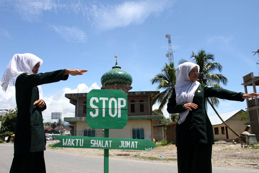 Polisi Syariat (Wilayathul Hisbah) wanita menjaga persimpangan dan mengalihkan jalur lalu lintas di kawasan yang berdekatan dengan masjid saat pelaksanaan ibadah shalat Jumat di Desa Meudang Ara, Blangpidie, Aceh Barat Daya, NAD, Jumat (25/10).   (Antara/I