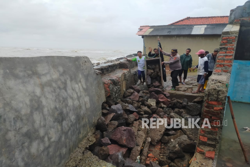 Polisi turun langsung  membantu perbaikan bocornya tanggul pembatas laut pemicu rob di Desa Eretan Kulon, Kecamatan Kandanghaur, Kabupaten Indramayu, Kamis (6/2/2025). 