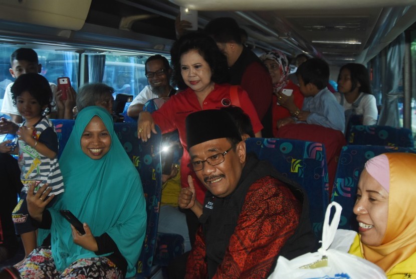 Politisi PDI Perjuangan yang juga Gubernur DKI Jakarta Djarot Saiful Hidayat (kedua kanan) berbincang dengan pemudik saat melepas rombongan Mudik Gotong Royong PDI Perjuangan di Jakarta, Kamis (22/6).