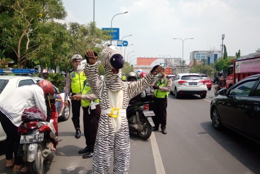  Polisi mengerahkan badut zebra untuk membantu menghentikan kendaraan lalu lintas dalam Operasi Zebra Jaya