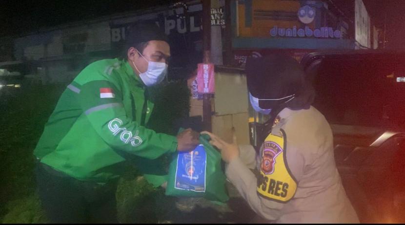Polres Sukabumi Kota membagikan paket sembako kepada pengemudi ojol di Jalan Protokol Kota Sukabumi, Sabtu (17/7) malam.