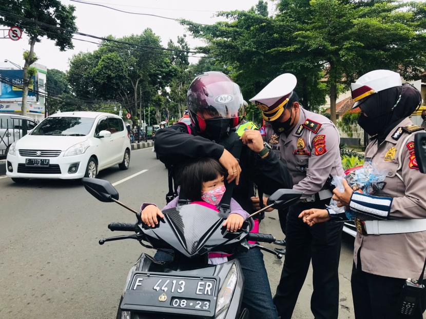 Polresta Bogor Kota membagikan sabuk keselamatan anak bagi pengendara motor yang membawa anak saat berkendara, pada Operasi Keselamatan Lodaya 2022, Selasa (1/3).