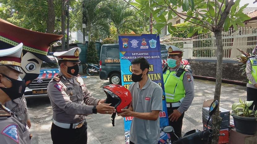 Polresta Malang Kota (Makota) menggelar Operasi Keselamatan Semeru 2022, di Jalan Raden Intan, Kota Malang, Rabu (2/3/2022). Pada kegiatan ini, aparat turut membagikan helm untuk pengguna kendaraan yang melintas. 
