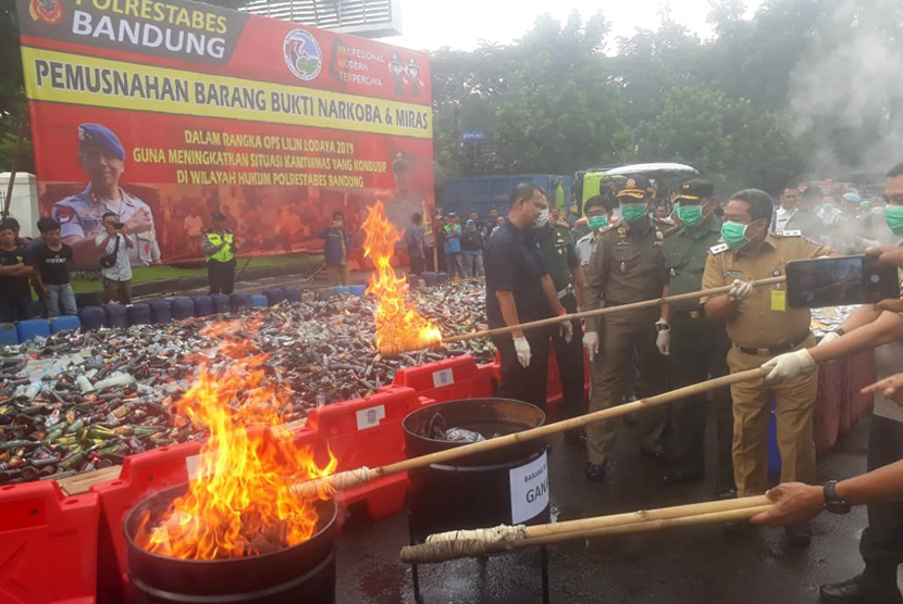 Polrestabes Bandung memusnahkan barang bukti 12 kilogram sabu, 843 batang pohon ganja, 18 ribu lebih minuman beralkohol dan 13 jerigen tuak di depan mapolrestabes Bandung, Senin (30/12).