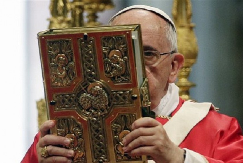 Pope Francis holds the book of the gospels as he celebrates a mass of Pentecost in St. Peter's Basilica, at the Vatican, Sunday, June 8, 2014. 
