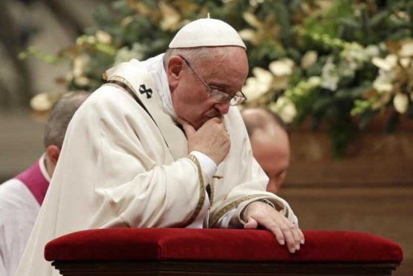 Pope Francis kneels as he leads the Christmas night mass in Saint Peter's Basilica at the Vatican December 24, 2014.