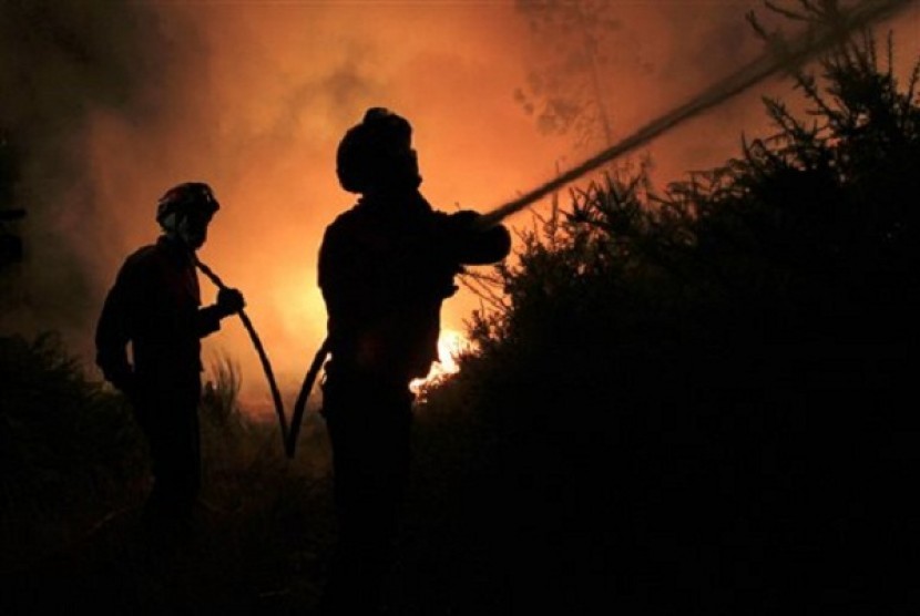 Portuguese firefighters work on a fire in Tondela, near Viseu, Portugal, Thursday night, Aug. 22, 2013. Portuguese authorities said one firefighter has died and six were injured as they battled a wildfire in Tondela. 