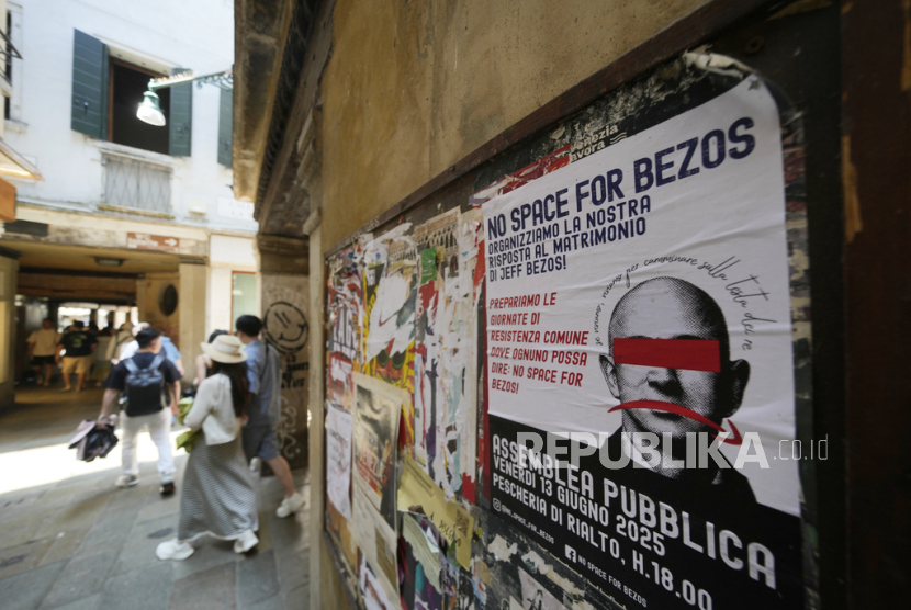 Poster anti rencana perkawinan Jeff Bezos terpampang di dinding di Venesia, Italia, Kamis (12/6/2025). 