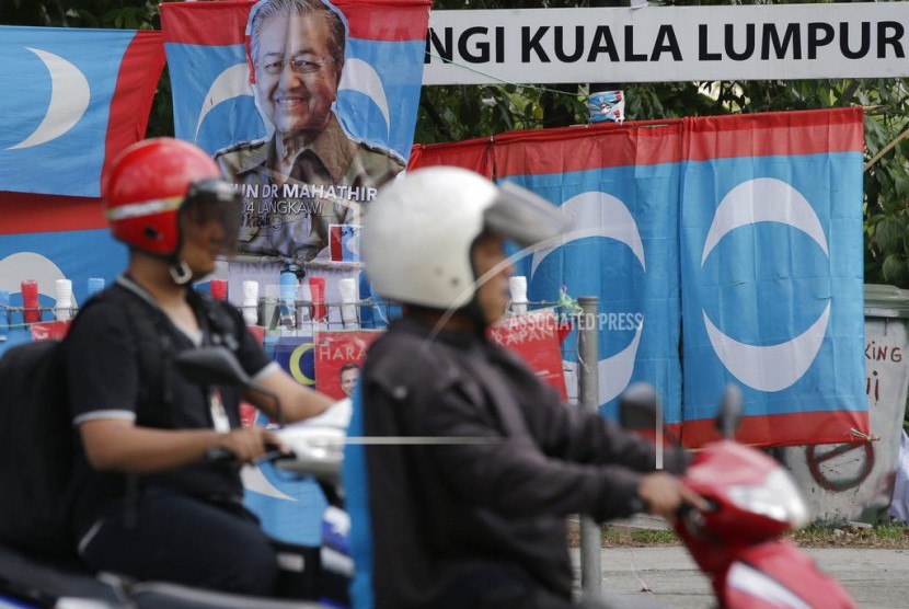 Poster kampanye Mahathir Mohamad ditampilkan di sepanjang jalan di Kuala Lumpur, Malaysia pada Kamis (10/5). Hasil resmi dari pemilihan nasional Malaysia menunjukkan aliansi oposisi yang dipimpin oleh Mahathir Mohamad telah memenangkan kursi mayoritas di parlemen, mengakhiri kekuasan 60 tahun Barisan Nasional.